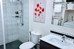 a white bathroom with a toilet and a sink at Very Close to Town- Mountain Views in Queenstown
