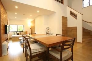 a dining room with a wooden table and chairs at KAMATA SANSO in Hakuba