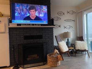 sala de estar con chimenea y TV de pantalla plana en Condo by the Sea en Lincoln City