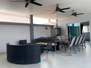 une salle à manger avec des chaises, des tables et des ventilateurs de plafond dans l'établissement walking st 1km south pattaya 5BR modern villa, à Pattaya