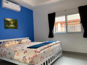 - une chambre dotée d'un lit avec un mur bleu dans l'établissement walking st 1km south pattaya 5BR modern villa, à Pattaya