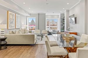 uma sala de estar com mobiliário branco e uma mesa de vidro em Luxury DC Penthouse w/ Private Rooftop! (Chapin 4) em Washington