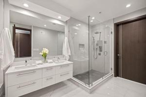 a bathroom with a shower and two sinks and a glass shower stall at Luxury DC Penthouse w/ Private Rooftop! (Chapin 4) in Washington, D.C.