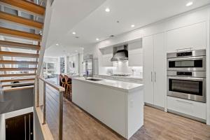 uma cozinha com armários brancos e electrodomésticos de aço inoxidável em Luxury DC Penthouse w/ Private Rooftop! (Chapin 4) em Washington