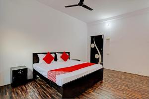 a bedroom with a bed with red pillows at OYO Flagship Hotel Samrat in Ghaziabad