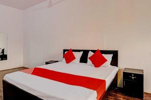 a bedroom with a large bed with red pillows at OYO Flagship Hotel Samrat in Ghaziabad