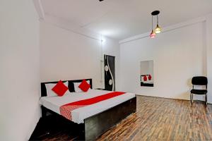 a bedroom with a bed with red pillows on it at OYO Flagship Hotel Samrat in Ghaziabad