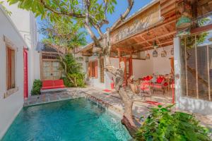 a villa with a swimming pool and a house at Bali Ginger Suites & Villa in Seminyak