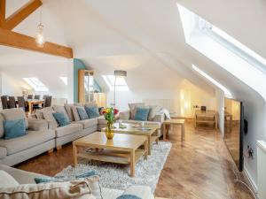 a living room with couches and a table at The Penthouse in Morfa Nefyn