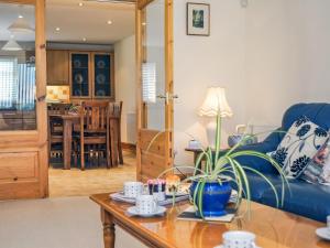 - un salon avec un canapé bleu et une table dans l'établissement Gelli Gron open Pastures, à Llangybi