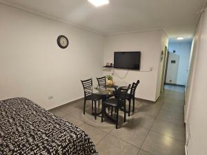 een slaapkamer met een tafel en stoelen en een televisie bij HOUSING CORDOBA - Laprida 2 in Cordoba