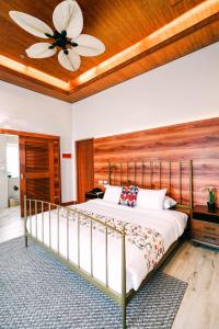 - une chambre avec un lit et un ventilateur de plafond dans l'établissement Hotel Kimberly Tagaytay, à Tagaytay