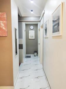 a hallway with white marble floors and a clock on the wall at Mimpi D View Homestay in Kuala Terengganu