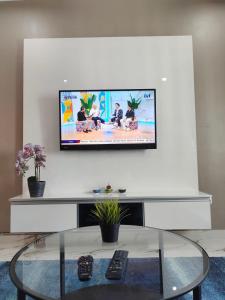 a flat screen tv on a white wall in a living room at Mimpi D View Homestay in Kuala Terengganu