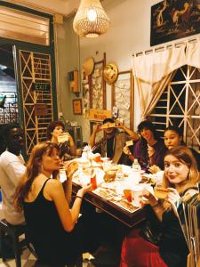 a group of people sitting around a table eating food at Coucou Homestead I - Homestay & Dorm District 1 in Ho Chi Minh City