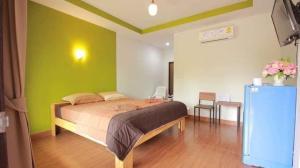 um quarto com uma cama com uma parede verde em The shark resort ปราณบุรี em Ban Khao Noi