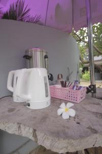 a kitchen counter with a mixer and flowers on a table at The shark resort ปราณบุรี in Ban Khao Noi