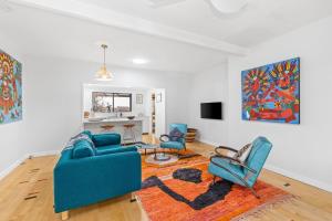a living room with a blue couch and chairs at Durras Cottage managed by Batemans Bay Accom in Durras