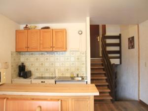 a kitchen with wooden cabinets and a staircase in the background at Studio Châtel, 1 pièce, 4 personnes - FR-1-200-380 in Châtel