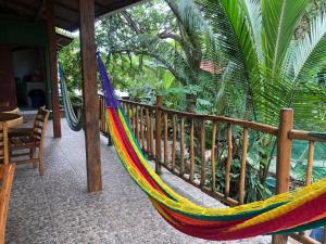 a hammock on a porch with a fence at El Marabu Surf Resort in Aposentillo