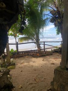 Aposentillo的住宿－El Marabu Surf Resort，享有棕榈树海滩和大海的景色