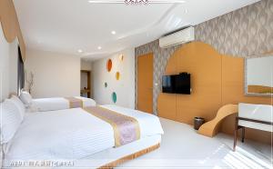 - une chambre avec 2 lits et une télévision à écran plat dans l'établissement 深溝仔庭園民宿, à Yuanshan