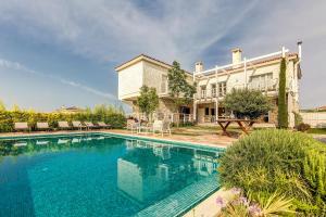 ein großes Haus mit einem davorliegenden Swimmingpool in der Unterkunft Ev Bharat Butique Hotel, Alaçatı in Alacati