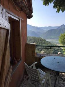 einen Tisch und Stühle auf einem Balkon mit einem Tisch in der Unterkunft Maisonnette avec terrasse et vue imprenable in Théus