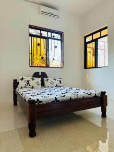 a bed sitting in a room with two windows at Paje Home in Paje