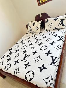 a bed with black and white comforters and pillows at Paje Home in Paje