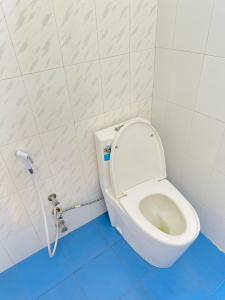 a white toilet in a bathroom with a blue floor at Paje Home in Paje +21 photos