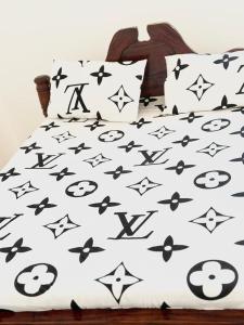 a bed with black and white comforter and pillows at Paje Home in Paje