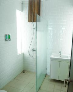 a white bathroom with a shower and a sink at Sampai Villa D'WOO in Jetis