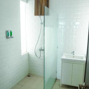 a white bathroom with a shower and a sink at Sampai Villa D'WOO in Jetis