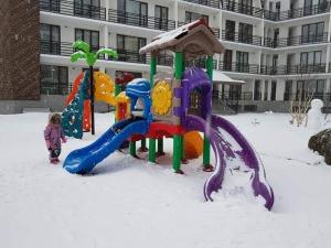 a child playing in the snow on a playground at Haystack - Room 127 in Bakuriani