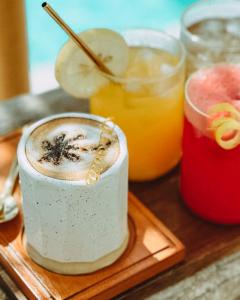 a wooden tray topped with a drink and two cocktails at Cahaya Villas - Luxury Villa With Private Pool in Gili Trawangan