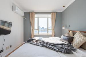 1 dormitorio con cama y ventana en Luxury Sky Suite, Downtown FFC, West Nanjing Rd, Floor Heating, 5 mins to subway en Shanghái