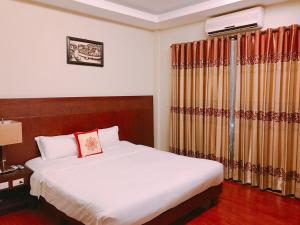 una camera d'albergo con letto e finestra di Little Gold Hue boutique hotel a Hue
