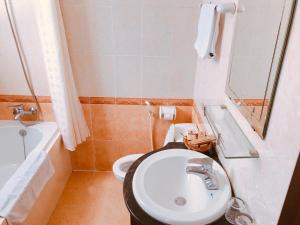 W łazience znajduje się umywalka, toaleta i lustro. w obiekcie Little Gold Hue boutique hotel w mieście Hue
