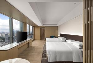 a hotel room with two beds and a flat screen tv at Renaissance Shenzhen Bay Hotel in Shenzhen
