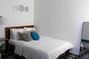 a bedroom with a bed with white sheets and pillows at NEWLY Renovated condo 5 min from Airport in Miami