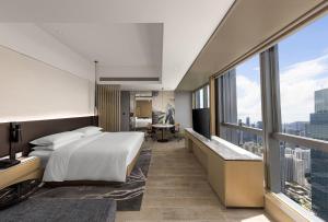 a hotel room with a bed and a large window at Renaissance Shenzhen Bay Hotel in Shenzhen