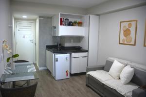 sala de estar con sofá y cocina en Na praia - Araça 104 - Térreo frente mar, en Natal