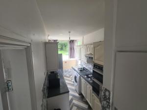 a small kitchen with a stove and a window at L & J ESCAPES-4 BEDROOMs SUITABLE FOR CONTRACTORS AND FAMILIES- LARGE PRIVATE PARKING-10 MINUTES TO M6 JUNCTION 9 in Coseley