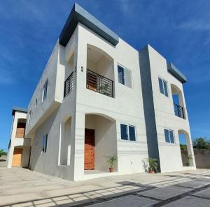 a large white house with a lot of windows at 'The Solace' New Luxury Modern 1Bed 1Bath Apt. in Portmore