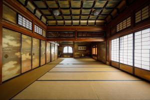 an empty hallway in a building with windows at Hotel Chourakukan Kyoto Gion 長楽館 京都 in Kyoto +130 photos