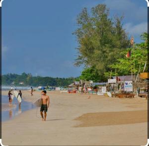 a group of people walking on the beach with surfboards at Calm Palace in Weligama +24 photos