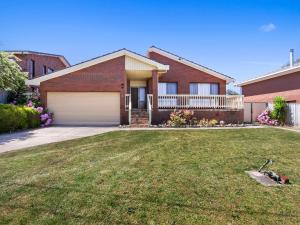 a house with a garage and a grass yard at Family Escape in Lakes Entrance