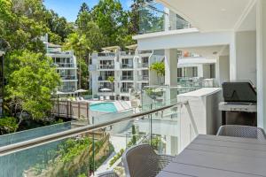 an apartment balcony with a view of a swimming pool at The Cove Noosa - Apartment 9 in Noosa Heads