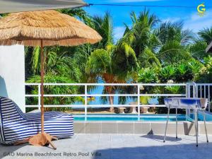 une terrasse avec une chaise, un parasol et une piscine dans l'établissement GAO Marina Retro Pool Villa, à Ban Phala